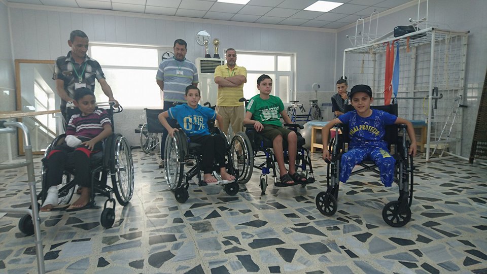 Rayyan, Abdul, Bakir, un altro bambino e i loro genitori nella sala fisioterapia del Centro di riabilitazione a Sulaimaniya